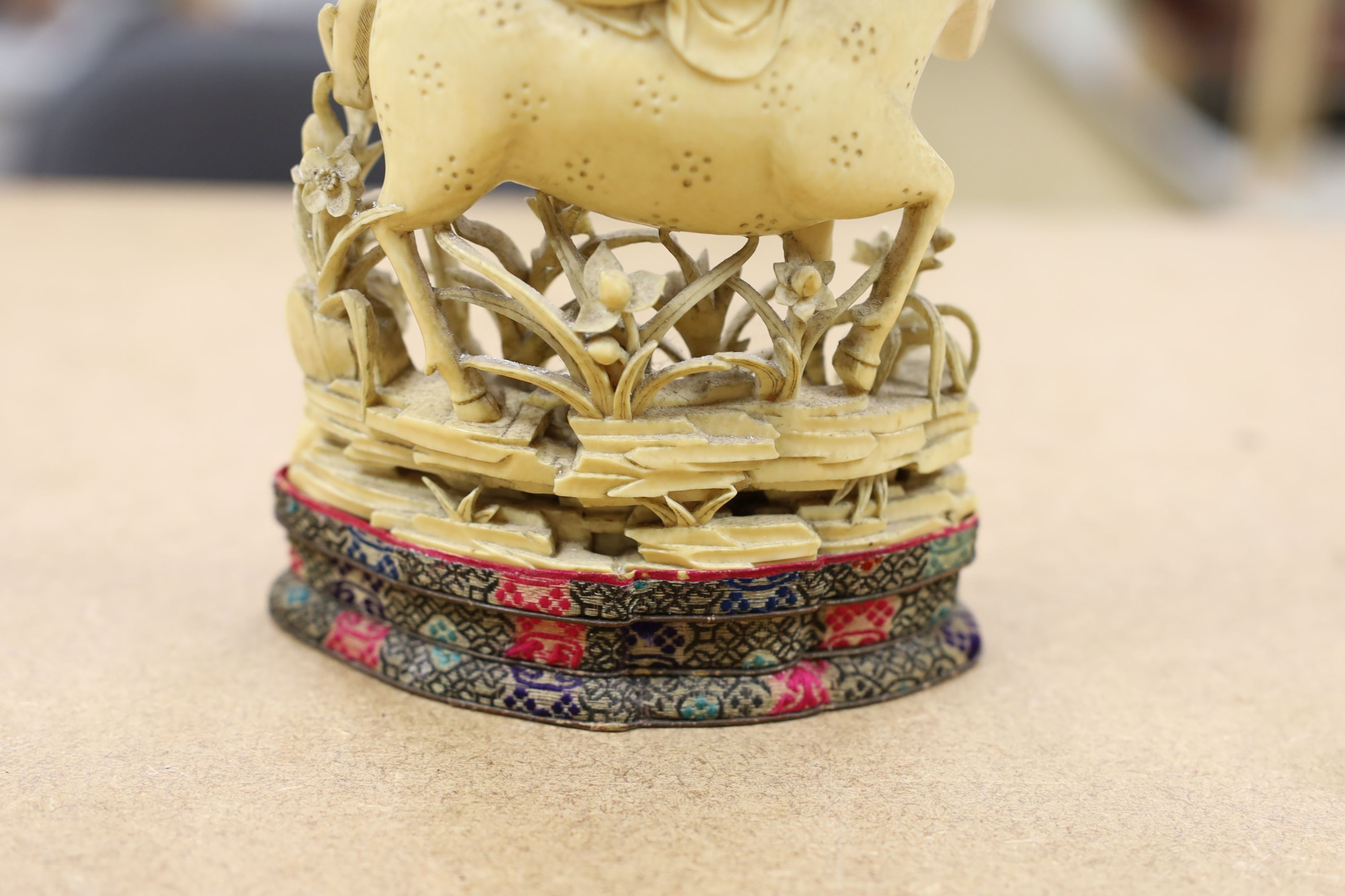 A Chinese carved ivory figure of a female immortal riding a deer, early 20th century, height 17cm excl. stand